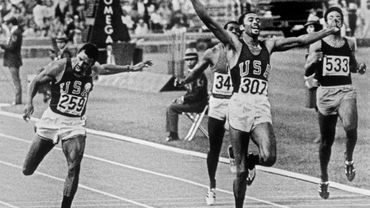 Les sprinters américains Tommie Smith (c) et John Carlos franchissent la ligne d'arrivée lors du 200 m aux Jeux Olympiques de Mexico, le 17 octobre 1968