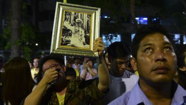 De nombreux thaïlandais brandissent des portrait du Roi devant l'hôpital où il est décédé