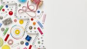 Overhead flat lay of colorful sewing items on white background Overhead flat lay of colorful sewing items on white background