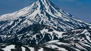 Le cône parfait du volcan Vilyuchinsky, la montagne zébrée par les traces de neige. Le cône parfait du volcan Vilyuchinsky, la montagne zébrée par les traces de neige.