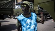 Un chauffeur de Forces Armées de la République Démocratique du Congo debout devant des camions militaires alignés le long du Boulevard du 29 octobre Un chauffeur de Forces Armées de la République Démocratique du Congo debout devant des camions militaires alignés le long du Boulevard du 29 octobre