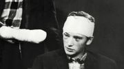 Photo du chanteur de rock français Johnny Hallyday et de son secrétaire, prise le 18 octobre 1961 sur le plateau des studios de Télé Lille, après son accident survenu sur la route Boulogne-Lille Photo du chanteur de rock français Johnny Hallyday et de son secrétaire, prise le 18 octobre 1961 sur le plateau des studios de Télé Lille, après son accident survenu sur la route Boulogne-Lille