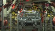 Les gros robots industriels dans les usines de voitures sont lourds et fixes, ils sont isolés physiquement des employés par sécurité Les gros robots industriels dans les usines de voitures sont lourds et fixes, ils sont isolés physiquement des employés par sécurité
