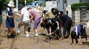 Les habitants tentent de dégager une route, à Hiroshima Les habitants tentent de dégager une route, à Hiroshima