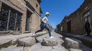 Female tourist jumping on stones in ruins of Pompeii, Naples, Italy Female tourist jumping on stones in ruins of Pompeii, Naples, Italy