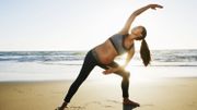 Pregnant Hispanic woman practicing yoga on beach Pregnant Hispanic woman practicing yoga on beach