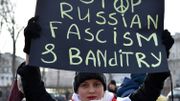 Une manifestante brandit une pancarte sur laquelle on peut lire "Stop au fascime et banditisme russe" Une manifestante brandit une pancarte sur laquelle on peut lire "Stop au fascime et banditisme russe"