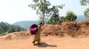 Une femme marche vers l'höpital de Panzi, portant ses affaires sur le dos Une femme marche vers l'höpital de Panzi, portant ses affaires sur le dos