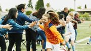 Young female soccer goalie high fiving parents on sidelines after soccer game Young female soccer goalie high fiving parents on sidelines after soccer game