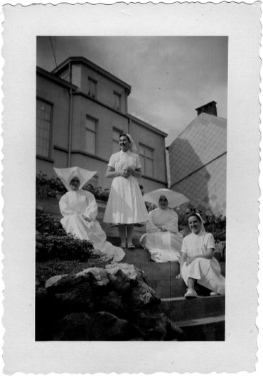 Lucy Deblon Marquet (en bas droite), devant la maison du directeur de l'école d'infirmières, avec deux religieuses et une autre étudiante. Lucy Deblon Marquet (en bas droite), devant la maison du directeur de l'école d'infirmières, avec deux religieuses et une autre étudiante.