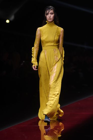 Chic victorien de tapis rouge chez Just Cavalli. La tenue jaune est garnie d'inserts en dentelle et de plis nervurés. Chic victorien de tapis rouge chez Just Cavalli. La tenue jaune est garnie d'inserts en dentelle et de plis nervurés.
