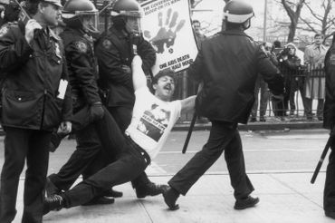 Des policiers arrêtent et traînent un manifestant lors d’une manifestation ACT UP à New York, en 1989. Il tient une affiche qui dit: "Le gouvernement a du sang sur ses mains : un mort par sida toutes les demi-heures." Des policiers arrêtent et traînent un manifestant lors d’une manifestation ACT UP à New York, en 1989. Il tient une affiche qui dit: "Le gouvernement a du sang sur ses mains : un mort par sida toutes les demi-heures."