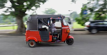 Un homme srilankais conduit un taxi à trois roues, appelé tuk-tuk, dans la ville de Colombo Un homme srilankais conduit un taxi à trois roues, appelé tuk-tuk, dans la ville de Colombo