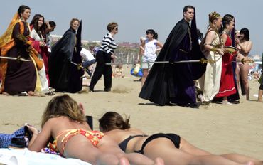 Procession de la confrérie du "Christ salvateur" à Valence, au milieu des personnes bronzant sur la plage. Procession de la confrérie du "Christ salvateur" à Valence, au milieu des personnes bronzant sur la plage.