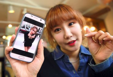 Jung Hye-Yoon (Ga-Bin), membre de SixBomb, montre une photo d'elle avant ses opérations de chirurgie esthétique le 16 mars 2017 à Séoul Jung Hye-Yoon (Ga-Bin), membre de SixBomb, montre une photo d'elle avant ses opérations de chirurgie esthétique le 16 mars 2017 à Séoul