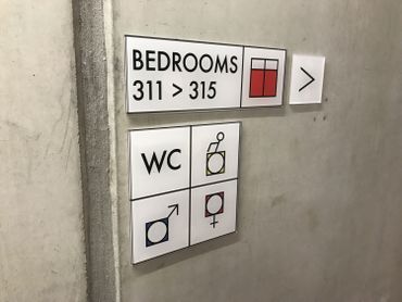 Des murs en béton apparent et une signalétique moderne pour orienter les clients. Des murs en béton apparent et une signalétique moderne pour orienter les clients.