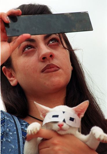 A Islamabad (Pakistan), une jeune femme observe l'éclipse du 11 août 1999, munie de lunettes protectrices. Par humour ou par inquiétude pour la vue du félin, elle a pris soin de protéger les yeux de son chat. A Islamabad (Pakistan), une jeune femme observe l'éclipse du 11 août 1999, munie de lunettes protectrices. Par humour ou par inquiétude pour la vue du félin, elle a pris soin de protéger les yeux de son chat.
