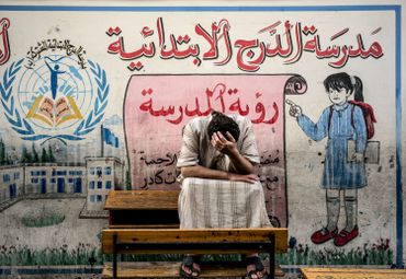 Un Palestinien déplacé du quartier de Chujaya, devant une école des Nations Unies Un Palestinien déplacé du quartier de Chujaya, devant une école des Nations Unies