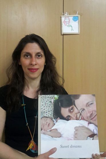 Nazanin Zaghari-Ratcliffe montrant une photo de sa fille Gabriella et de son époux. Nazanin Zaghari-Ratcliffe montrant une photo de sa fille Gabriella et de son époux.