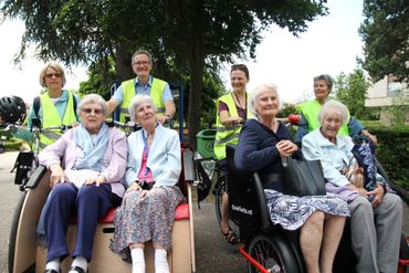 Tim Cooper (en haut à droite sur la photo de gauche) et des seniors à bord de son rickshaw Tim Cooper (en haut à droite sur la photo de gauche) et des seniors à bord de son rickshaw